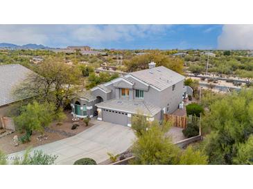 Two-story home showcasing desert landscaping, an attached two-car garage, and a neutral color scheme at 4801 E Quien Sabe Way, Cave Creek, AZ 85331