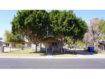 Charming single-story home featuring mature trees, a fenced yard, and classic curb appeal at 6212 S 12Th St, Phoenix, AZ 85042