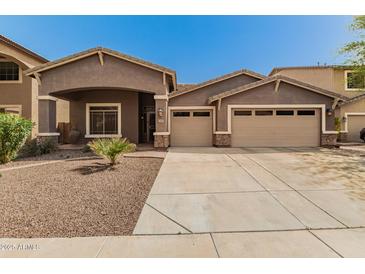 Charming single-story home featuring a three-car garage and desert landscaping at 6829 S 58Th Ave, Laveen, AZ 85339