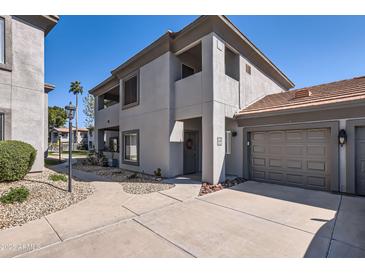 Two-story condo features neutral stucco, tile roof, two car garage, and well-manicured landscaping at 7401 W Arrowhead Clubhouse Dr # 2045, Glendale, AZ 85308