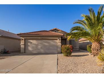 Charming single-story home featuring a two-car garage, low maintenance landscaping, and a red tile roof at 1010 E Vernoa St, San Tan Valley, AZ 85140