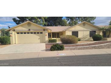 Charming single-story home with a two-car garage, desert landscaping, and mature trees in a sunny neighborhood at 19527 N 142Nd Dr, Sun City West, AZ 85375