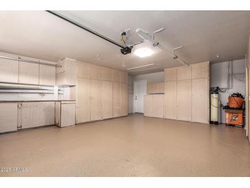 Spacious garage with epoxy flooring, abundant storage cabinets, and overhead lighting at 2149 S Olivewood --, Mesa, AZ 85209