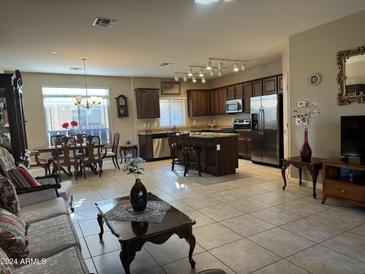 Spacious living room featuring tile flooring, a kitchen island and dining area at 2150 W Alameda Rd # 1119, Phoenix, AZ 85085