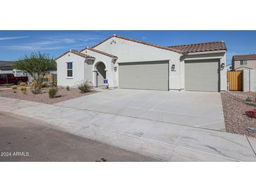 Charming single-story home featuring a three car garage and desert landscaping at 35680 W Mallorca Ave, Maricopa, AZ 85138