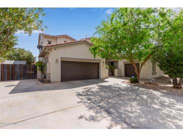 A tan home featuring a 3-car garage with a large driveway and desert landscaping at 3797 E Taurus Pl, Chandler, AZ 85249