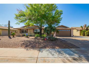 Charming single-story home with a well-maintained yard, mature tree, and a two-car garage at 4111 W Hayward Ave, Phoenix, AZ 85051