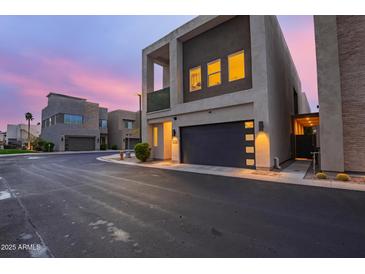 Contemporary home features a modern design with a dark garage door and a light-colored stucco exterior at 6804 E Lyra Dr, Scottsdale, AZ 85257