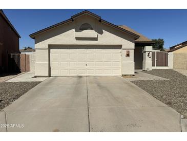 Home featuring a two-car garage, neutral exterior, and low-maintenance landscaping at 7410 W Eva St, Peoria, AZ 85345