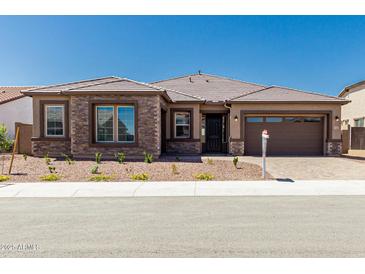 Beautiful single-story home featuring stone accents, a tile roof, and a well-manicured front yard at 20261 W Monterey Way, Buckeye, AZ 85396