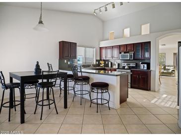 Open kitchen with dark wood cabinetry, dining area, and modern lighting at 25879 W Elizabeth Ave, Buckeye, AZ 85326