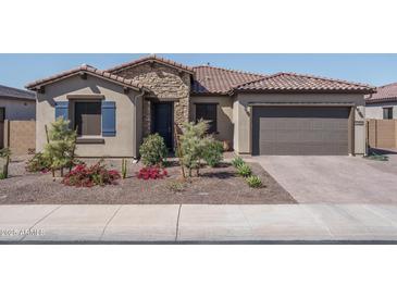 Charming single-story home featuring a stone facade, tile roof, and well-maintained landscaping in a desirable neighborhood at 7250 N 80Th Ln, Glendale, AZ 85303