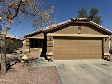 Charming single-story home with a well-maintained front yard and a two-car garage at 12046 W Scotts Dr, El Mirage, AZ 85335