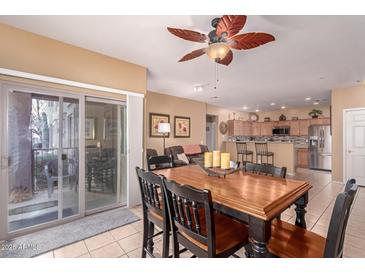 Inviting dining area with wood table, tile flooring, and a view extending to the living area and sliding glass door at 12050 N Panorama Dr # 104, Fountain Hills, AZ 85268