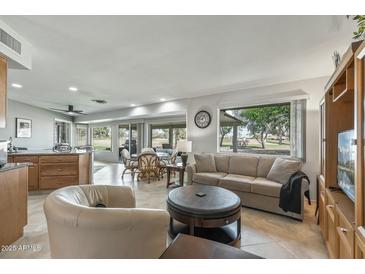 Inviting living room featuring large windows with views of the golf course at 12822 W Ballad Dr, Sun City West, AZ 85375