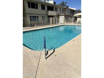 Refreshing community pool surrounded by a secure fence and lounging area in a well-maintained apartment complex at 2605 W Rose Lane -- # B201, Phoenix, AZ 85017