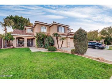 Charming two-story home featuring a well-manicured lawn, desert landscaping, and a welcoming double-door entrance at 913 W Juanita Ave, Gilbert, AZ 85233