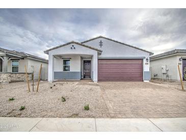 Home with modern design, a brick driveway, and desert landscaping at 17567 W Adams St, Goodyear, AZ 85338