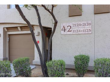 View of building number 42 with desert landscaping and garage at 19700 N 76Th St # 1124, Scottsdale, AZ 85255