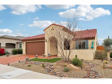 Charming single-story home featuring a desert landscape, red tile roof, and a welcoming arched entrance at 27467 W Osprey Dr, Buckeye, AZ 85396