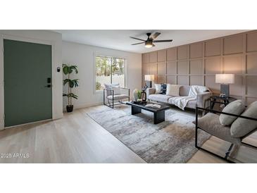 Inviting living room with paneled wall, stylish seating, a large window, and a green door at 3207 W Royal Palm Rd, Phoenix, AZ 85051