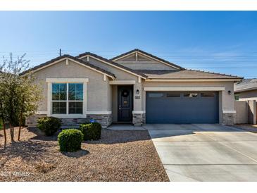 Charming single-story home with a well-manicured lawn and a two-car garage in a Gathering-friendly neighborhood at 37783 W San Sisto Ave, Maricopa, AZ 85138