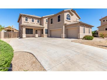 Spacious two-story home with a three-car garage and large concrete driveway, perfect for a growing Gathering at 41800 W Chambers Ct, Maricopa, AZ 85138