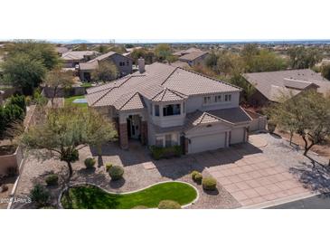 Aerial view of the property showcasing its well-maintained landscaping, three-car garage and tile roof at 6929 E Trailridge Cir, Mesa, AZ 85207