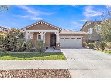 Inviting one-story home with a two-car garage, neutral paint, covered entry, and fresh landscaping at 7115 E Olla Ave, Mesa, AZ 85212