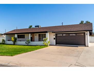 Charming single-story home showcasing a well-manicured lawn, covered porch, and a two-car garage at 7811 N 32Nd Ave, Phoenix, AZ 85051