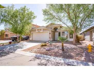 Charming single-Gathering home featuring a well-maintained front yard with desert landscaping and mature trees at 85 W Grey Stone St, San Tan Valley, AZ 85143