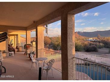 Relaxing balcony area with decorative seating and mountain views, overlooking desert landscaping at 9736 E Sleepy Hollow Trl, Gold Canyon, AZ 85118