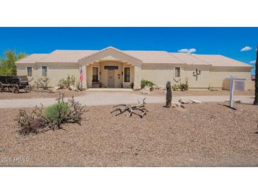 Wide front view of a well-maintained single-story house with desert landscaping and covered entryway at 9736 E Sleepy Hollow Trl, Gold Canyon, AZ 85118