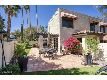 Charming back patio with stone tiles, seating area, pergola, and beautiful landscaping at 1803 E Hayward Ave # 1, Phoenix, AZ 85020