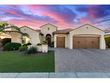 Stunning single-story home showcasing meticulously landscaped grounds and a beautiful paver driveway at 3234 N 163Rd Dr, Goodyear, AZ 85395