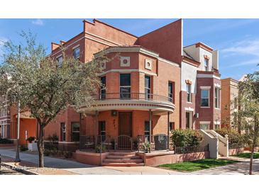 Charming multi-story townhome with brick facade, unique architectural details, and a welcoming front porch and manicured landscaping at 605 S Roosevelt St, Tempe, AZ 85281