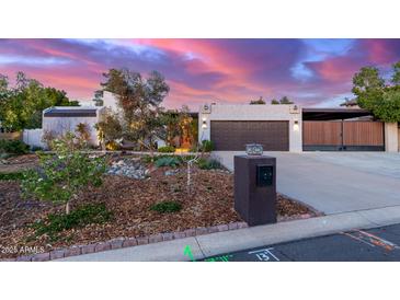 Charming single-story home featuring a well-manicured yard, complemented by a two-car garage and private courtyard at 6338 E Camelot Dr, Mesa, AZ 85215