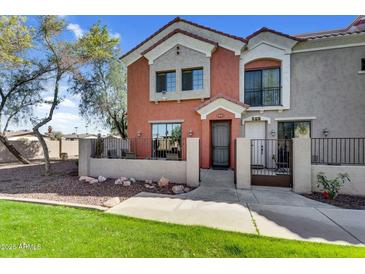 Two-story townhome with desert landscaping and stucco exterior. Front patio with gate at 1950 N Center St # 101, Mesa, AZ 85201