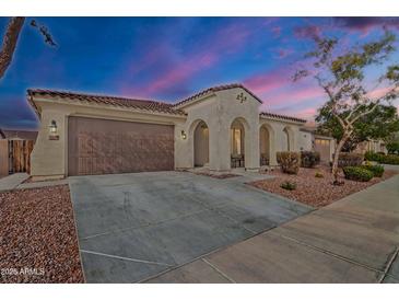 Charming single-story home featuring a two-car garage, arched entryway, and well-maintained desert landscaping at 3690 E Blue Spruce Ln, Gilbert, AZ 85298