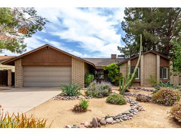Single-story home featuring desert landscaping, a two-car garage and a paved driveway at 4839 E Marilyn Rd, Scottsdale, AZ 85254