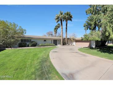 Charming single-story home featuring mature landscaping, a circular driveway, and a well-manicured lawn at 6320 N 4Th Pl, Phoenix, AZ 85012