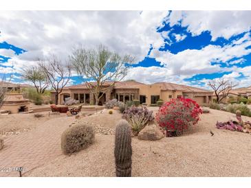 Stunning single-story home featuring a tiled roof and desert landscaping with cacti and flowering bushes at 7013 E Summit Trail Cir, Mesa, AZ 85207