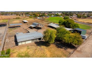 Expansive property featuring horse facilities, covered parking, green pastures, and a comfortable home at 836 W Lenora Way, San Tan Valley, AZ 85140