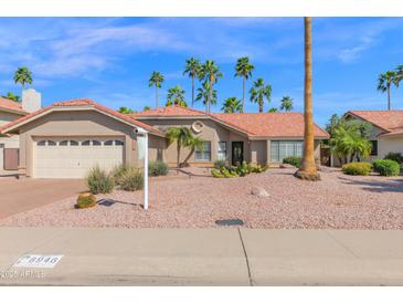 Charming single-story home with a well-maintained desert landscape and beautiful palm trees at 8946 E Voltaire Dr, Scottsdale, AZ 85260