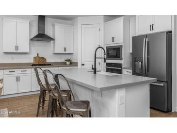 Modern kitchen features a large island with bar seating, stainless steel appliances, and white cabinets at 9718 E Radioactive Dr, Mesa, AZ 85212