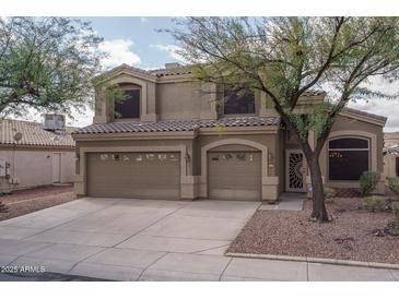 Charming two-story home featuring a three-car garage, desert landscaping, and well-maintained stucco exterior at 14406 N 129Th Ave, El Mirage, AZ 85335