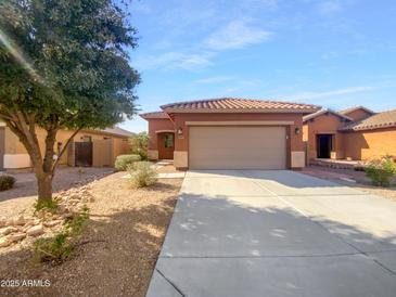 Inviting single-story home featuring a charming desert landscape and a tile roof at 45997 W Windmill Dr, Maricopa, AZ 85139