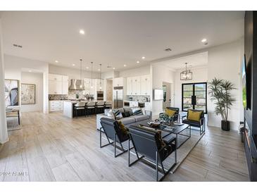 Spacious living room with modern decor, sleek furniture, and an open floor plan into the kitchen at 510 E Woburn Ln, Phoenix, AZ 85085