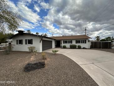 Charming single-story home with a well-manicured front yard and a curved driveway at 8601 E Berridge Ln, Scottsdale, AZ 85250