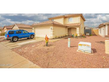 Two-story home features a two car garage, low maintenance landscaping, and covered front porch at 11234 W Roma Ave, Phoenix, AZ 85037